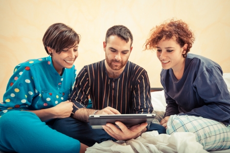Friends on the Bed with Tablet PCの写真素材