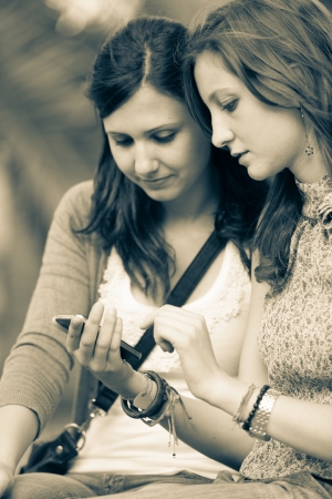 Two Beautiful Women Sending Messages with Mobileの写真素材