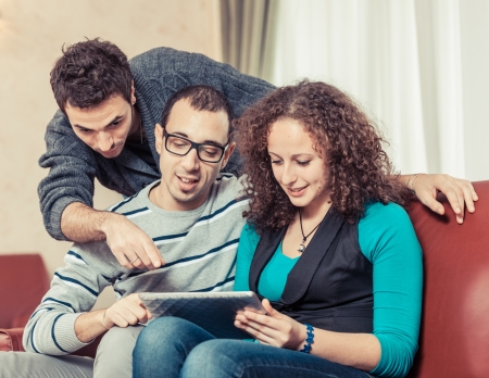 Three Friends with Tablet PC on a Sofaの写真素材