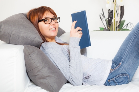 Beautiful Young Woman with a Book on the Sofaの写真素材