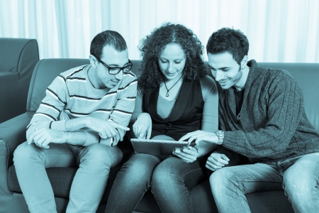 Three Friends with Tablet PC on a Sofaの写真素材