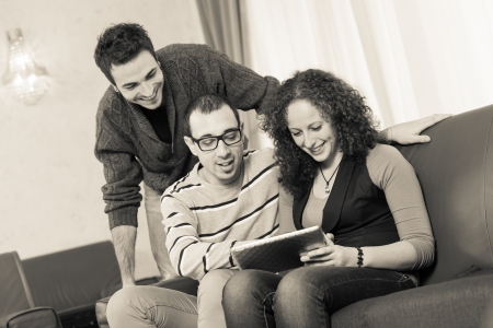 Three Friends with Tablet PC on a Sofaの写真素材