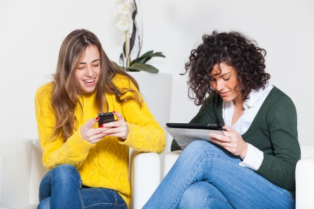Two Women with Technological Devicesの写真素材