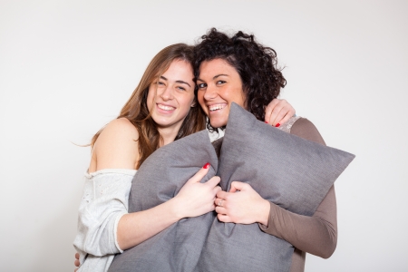 Two Beautiful Women with Pillow in the Bedroomの写真素材