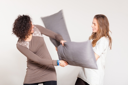 Pillow Fight between Two Beautiful Womenの写真素材