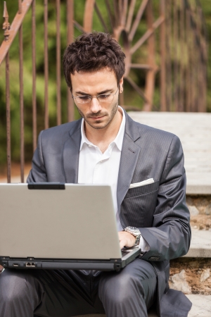 Young Businessman with Computer next to Swimming Poolの写真素材