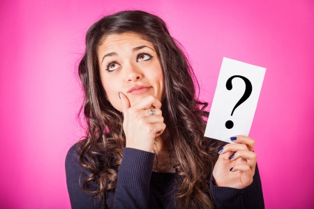 Doubtful Woman holding Question Markの写真素材