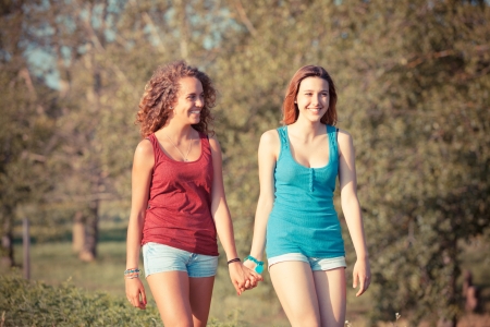 Two Beautiful Teenage Girls Walking at Parkの写真素材