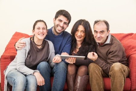 Happy Family on the Sofa with Digital Tabletの写真素材