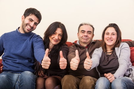 Happy Family on the Sofa with Thumbs Upの写真素材