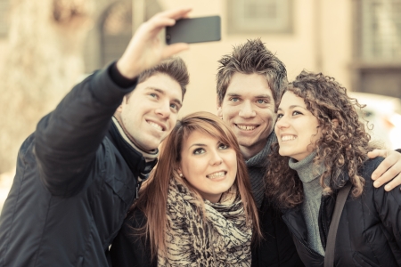 Group of Friends taking Self Portraits with Mobile Phoneの写真素材
