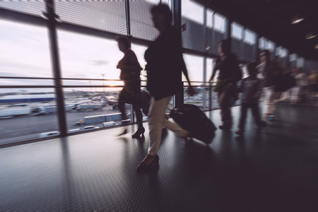 Blurred Passengers Walking at Airport Terminalの写真素材