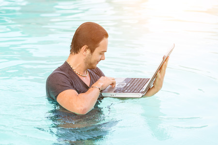 Ma with Computer in the Swimming Poolの写真素材