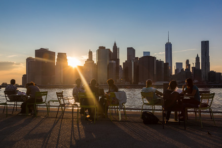 NEW YORK, USA - AUGUST 25, 2014: People resting at sunset  in Brooklyn Bridge Park with Lower Manhattan on backgroundのeditorial素材