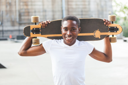 Black Boy with Longboard at Parkの写真素材
