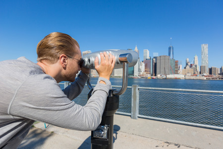Young Man Looking through Binoculars in New Yorkの写真素材
