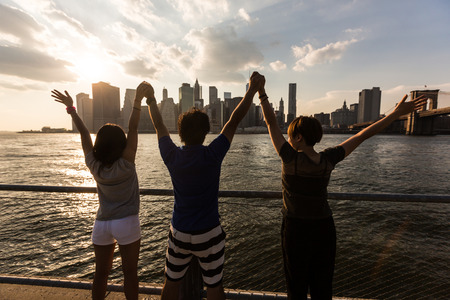 Happy Japanese Tourists with Raised Arms in New Yorkの写真素材