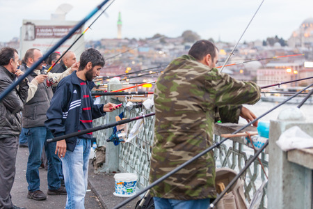 ISTANBUL, TURKEY - OCTOBER 25, 2014: Lots of fishermen fishing on Galata Bridge on a rainy day.のeditorial素材