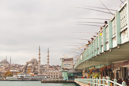 ISTANBUL, TURKEY - OCTOBER 26, 2014: View of Yeni Camii (the New Mosque) and Galata brigde woth lot of fishermen fishing.のeditorial素材