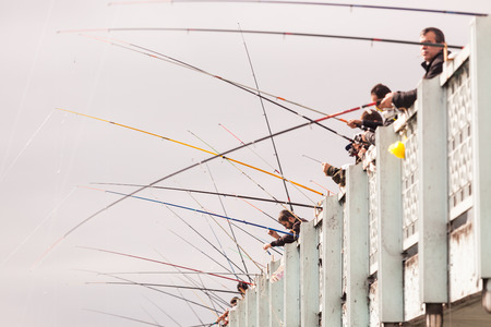 ISTANBUL, TURKEY - OCTOBER 26, 2014: Lots of fishermen fishing on Galata Bridge on a cloudy day.のeditorial素材