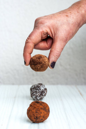Elderly Woman Picking Up Chocolate Bitesの写真素材