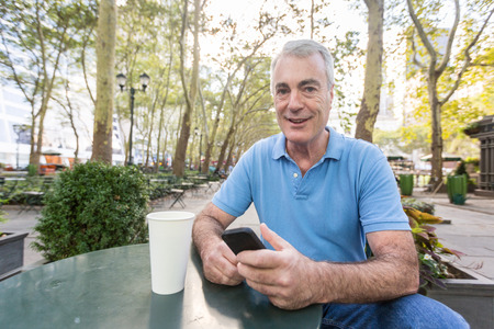 American Senior Man with Mobile Phone at Park
