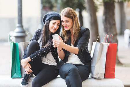 Happy Women with Smart Phone and Shopping Bagsの写真素材