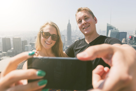 Young Couple Taking Selfie with New York on Background