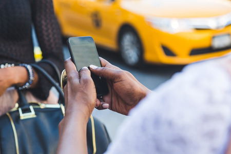 Two Beautiful Black Woman Using Smart Phone in New Yorkの写真素材