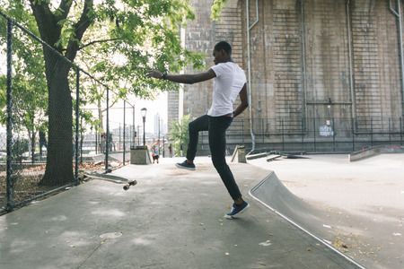 Black Boy Skating at Park and Falling Downの写真素材