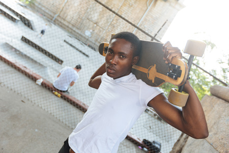 Black Boy with Longboard at Parkの写真素材