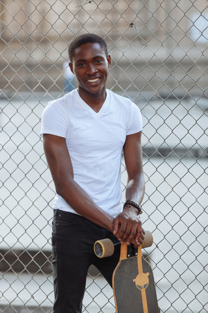 Black Boy with Longboard at Parkの写真素材
