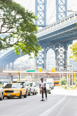 Black Boy Skating with Longboard on the Roadの写真素材