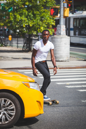 Black Boy Skating with Longboard on the Roadの写真素材