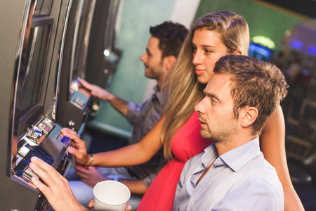 Group of Friend Playing with Slot Machinesの写真素材