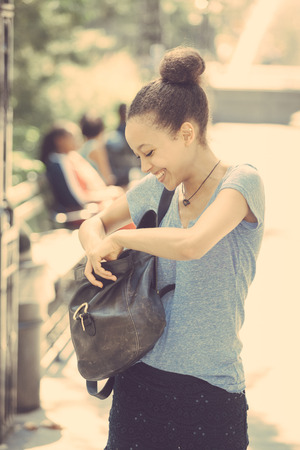 Beautiful Mixed-Race Young Woman Looking Inside Her Bagの写真素材