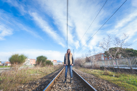 Beautiful Young Woman Walking on Railway Tracks. The Railroad is in a Residential Aerea. The Girl...