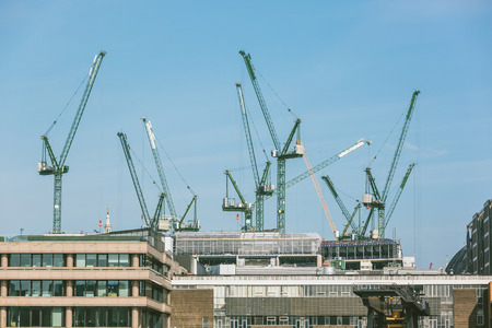 Cranes on a building site in London next to Thames. London skyline is full of cranes and new buildings are build every year.の写真素材