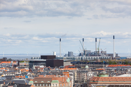 Power plant in Copenhagen next to the sea, the strait of Oresund, with high cimneys and wind turbines. Panoramic aerial view.の写真素材
