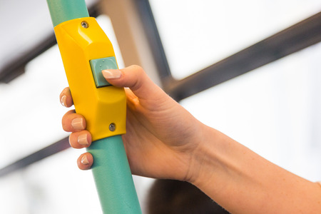 Young woman pressing stop request button on the bus in London. Close up shot on the hand.の写真素材