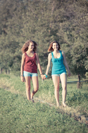 Two Beautiful Teenage Girls Walking at Parkの写真素材