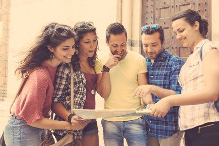 Tourists looking at city map with typical Italian street on background. The photo was taken in Pisa but could also be used for Rome, Florence or Milan.の写真素材