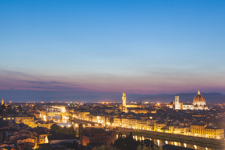 Panoramic view of Florence at dusk. From left to right there are Ponte Vecchio, Palazzo Vecchio and Santa Maria del Fiore cathedral. Photo taken at dusk, with blue sky.の写真素材