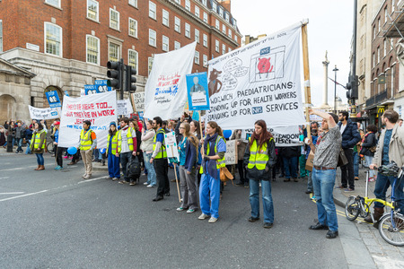 LONDON, UK - OCTOBER 17, 2015: Thousands Junior doctors marching in London streets to campaign against NHS contract changesのeditorial素材