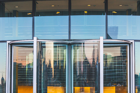 Abstract view of a modern building entrance. Glass and steel are main materials, main colors are gray and green. Photo taken in London. It could be used as background.の写真素材