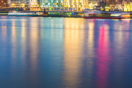 Colorful reflections on Thames river in London. Picture taken in the night with lights of buildings and skyscrapers reflecting into the water. Background and abstract.の写真素材