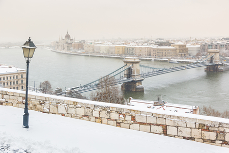 Winter snowy panoramic view of Budapest from the hill, with Danube river, Chain bridge and the parliament palace on background. Season and travel concepts on this postcard ready photo.の写真素材