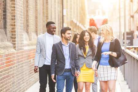 Business multiracial group walking in London. They all are young, smiling and wearing smart casual clothes. Mixed race group. Teamwork and business concepts.の写真素材
