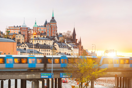 Stockholm, view of buildings and train at dusk. Long exposure shot, with blurred train on the bridge. Typical scandinavian architecture and colors. Travel and tourism concept.の写真素材