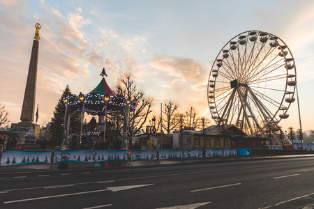 LUXEMBOURG, LUXEMBOURG - DECEMBER 8, 2016: Christmas market and amusement park in "Place de la Constitution" at sunset. On the left there is the Golden Lady monument.のeditorial素材